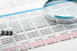 © Dmytro - Close up of finance business sheet with pen and  magnifying glass