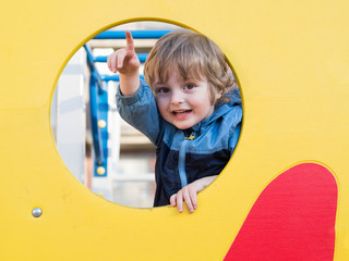 Funny cute happy baby playing on the playground. The emotion of happiness, fun, joy. Smile of a ?hild.