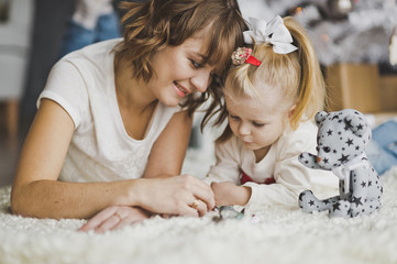 Close-up portrait of mother with daughter playing lying on the f