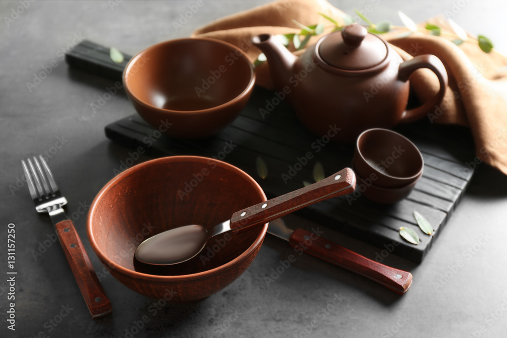 Set of dishes and cutlery on gray background