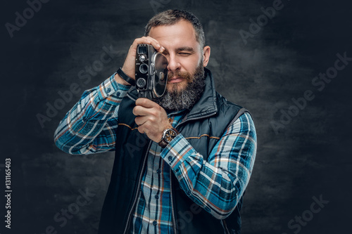 Fotografie, Obraz Bearded middle age male holds vintage 8 mm video camera.