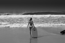 The Girl Walks Into The Ocean With A Board