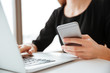 © Drobot Dean - Cropped photo of young woman worker using laptop and telephone.