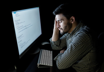 stressed software developer with computer at home office
