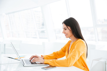 Side view Business woman using laptop computer by the table