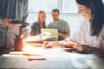 Joyful team brainstorming. Digital plan researching. Paperwork on the table, laptop and mobile phone. Statistic graph overlay, icon innovation interface