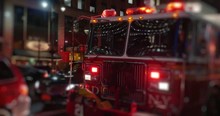 A Fire Truck With Flashing Red Lights Sits Outside A Manhattan Apartment Building At Night.	 	
