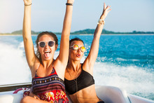Two Beautiful Sexy Happy Hipster Girl Ride On A Speed Boat, The Girls Laugh And Lifted Up His Hands, Lifestyle, Crazy Emotions, Glamor Sunglasses, Bikini, Wet Hair And Skin, Perfect Bodies Accessories