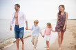 © Connect Images - Family holding hands walking on beach