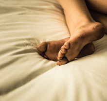 Cropped View Of Boys Dirty Bare Feet On Bed