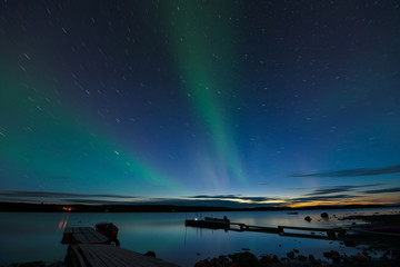 star trails and aurora - long exposure to capture star trails and light aurora borealis over a lake 