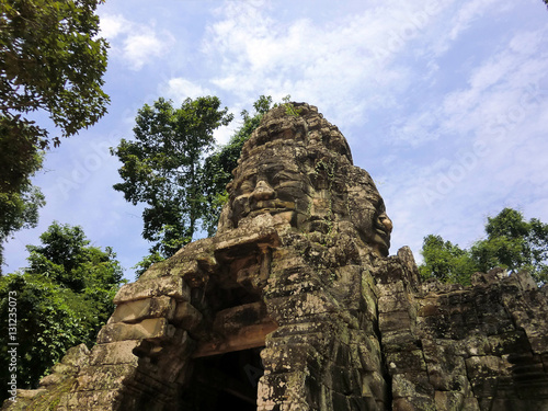 Bayon face carved in ancient abandoned lost temple in Siem Reap, Cambodia Poster
