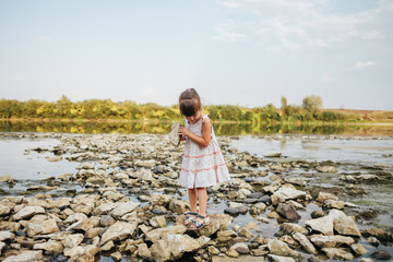 girl holding a dry stone of the river