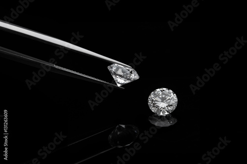 Zdjęcie XXL luźne, genialne diamenty, jedna jest trzymana przez pincetę na odbijającym czarnym tle