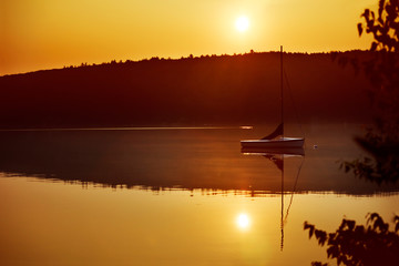 Wall Mural - Sailboat on calm Merrymeeting Lake at sunrise