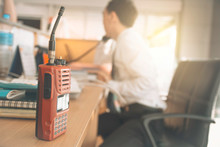 Walkie-talkie Radio On Wooden Table Operator In Office.