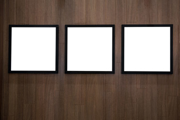 Three empty white isolated frame on the wood wall