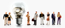 Miniature People In Front A Light Bulb With Euro Coins Inside