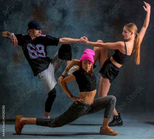 Naklejka dekoracyjna The two young girsl and boy dancing hip hop in the studio