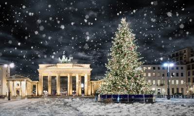 Brandenburger Tor in Berlin mit Weihnachtsbaum bei Nacht und Schneefall