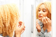 Starzenie skóry.
Kobieta przegląda się w lustrze wypatrując pierwszych oznak starzenia.

