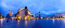 Cloth Hall Well Known As Sukiennice, St. Mary's Church And The Clock Tower At Night. Panoramic View Of Market Square - Main Square In Old City. Krakow Poland.