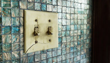 Old And Broken Switch Control On Blue And Gold Color Mosaic Tiles Wall On Side 