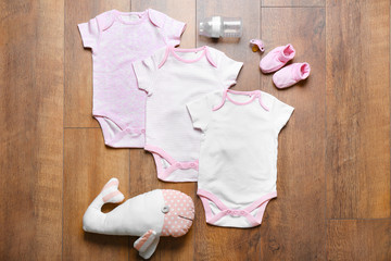 Wall Mural - Baby clothes and necessities on wooden background