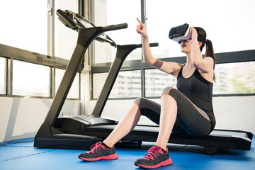 Wall Mural - beauty asian woman rest on treadmill with VR headset