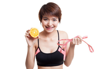 Wall Mural - Asian healthy girl on diet with orange fruit and measuring tape.