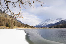 Engadin Valley In Switzerland Sils Maria Village With Snow On Alp Mountains And Frozen Lake