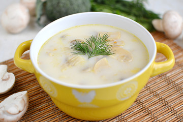 Delicious soup with cheese and mushrooms in a yellow plate