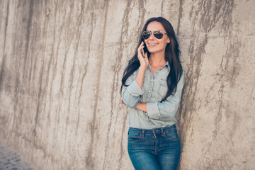 Wall Mural - Stylish pretty brunette in glasses  having conversation on phone