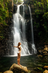 Wall Mural - Young woman in bikini standing by Middle Tavoro Waterfalls in Bo