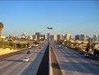  Urban landscape of city skyline and freeway with commercial plane landing