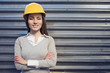 beautiful woman engineer is standing in front of an industrial wall