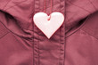 Cute rose safety reflector in the form of heart on the winter jacket. Necessary equipment to pedestrians for walks during dark conditions.