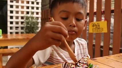 Wall Mural - Cute asian  little boy eating sweetmeat