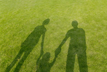 幼児と手を繋ぐ3人の影、家族のイメージ