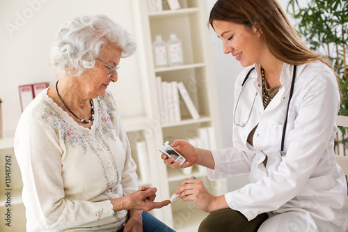 Fotografía Young female doctor making diabetes blood test on senior woman