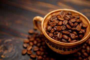 mug with roasted coffee beans on wooden background