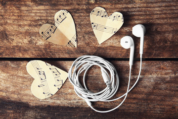 Poster - Paper hearts with music notes and earphones on wooden background