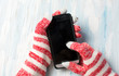 © creativefamily - Hands using phone in winter gloves