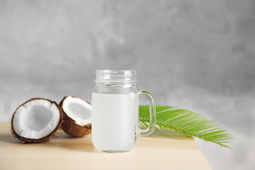 Glass of coconut milk and nuts on wooden table