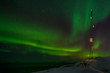 Communication tower and northern lights with a fjord in the back
