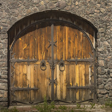 Gothic Wooden Door With Wrought Iron Elements In The Stone Wall