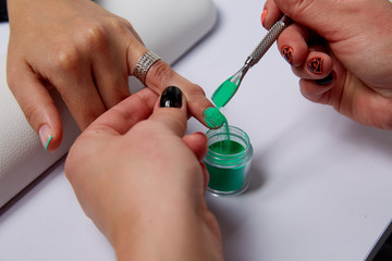 Close Up of Women Hands with Painted Nails and Coordinating Mineral Eye Shadows Swatches in Festive Colors on Black Background