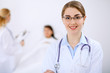 © rogerphoto - Female doctor smiling on the background with patient and his doctor