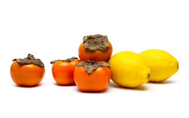 ripe persimmons and lemons on a white background