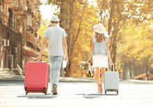 Just Married Couple With Suitcases Walking Back In The Street
